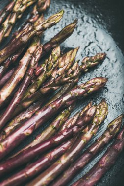 Taze çiğ çiğ mor kuşkonmaz koyu arka plan üzerinde