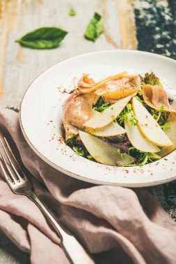 Füme hindi jambon ve armut scorched rustik ahşap masa arka plan üzerinde beyaz tabak içinde dilim taze yaz salatası