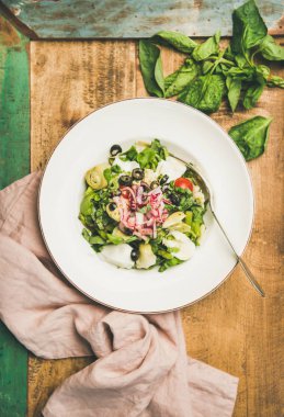 Enginar, zeytin, peynir ve rustik ahşap masa arka plan üzerinde beyaz tabak içinde kırmızı soğan taze yeşil yaz salatası