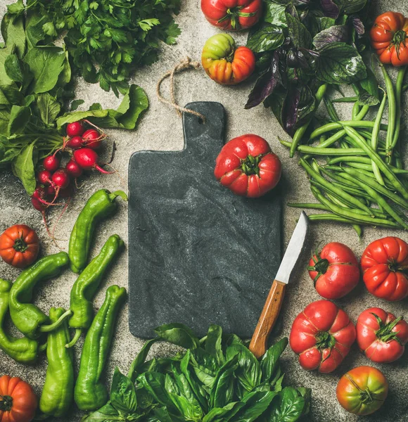 健康的季节性食品烹饪背景 蔬菜和绿色的混凝土背景 黑色大理石砧板在中心 — 图库照片