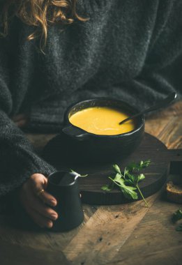 Tatlı Mısır ve karides çorbası çorba siyah kaseden yemek koyu gri kış kazaklı kadın.