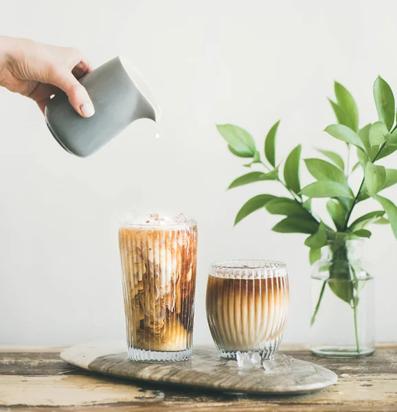 Iced Coffee Tall Glasses Milk Pouring Pitcher Hand White Wall — Stock Photo, Image