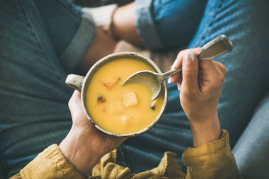 Kadın oturma croutons sonbahar ısınma kupa kabak kremalı çorba tutmak
