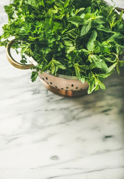 大理石の台所のテーブルの上の真鍮のザルで新鮮な緑の庭のハーブの束 — ストック写真