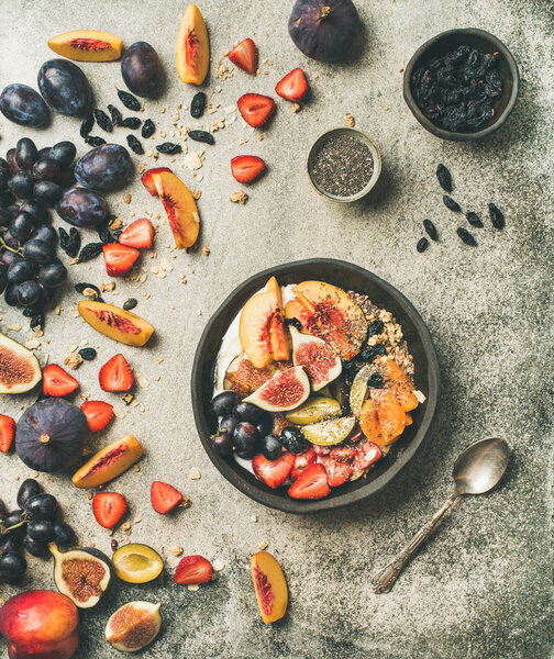 Healthy seasonal fall breakfast variety. Greek yogurt, fresh fruit, chia seeds bowl over grey concrete background