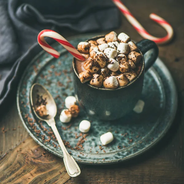 Winter warming sweet drink hot chocolate with marshmallows and cocoa in mug with Christmas holiday candy cane, selective focus, copy space, square crop