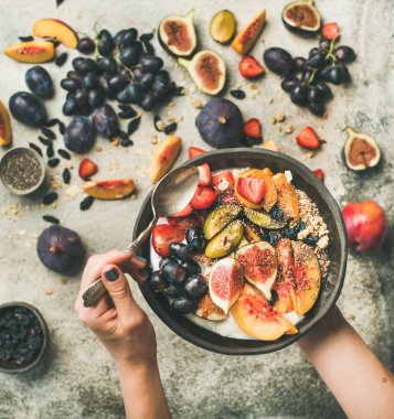 Sağlıklı mevsim sonbahar kahvaltı çeşitli. Yunan yoğurt, taze meyve, chia tohum kapta eller gri beton tablo arka plan, üstten görünüm, kopya alanı kadın. Temiz beslenme, diyet, vejetaryen yemek