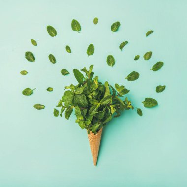 Düz-lay gözleme tatlı koni açık mavi pastel renkli, üstten görünüm, yatay kompozisyon taze nane ile. Bahar ya da yaz ruh kavramı, kare kırpma