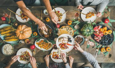 Geleneksel Şükran günü veya Friendsgiving tatil kutlama partisi. Düz-lay Türkiye, kabak pasta, kavrulmuş mevsimlik sebze ve meyve, üstten görünüm ile Şükran günü masada şölen arkadaş