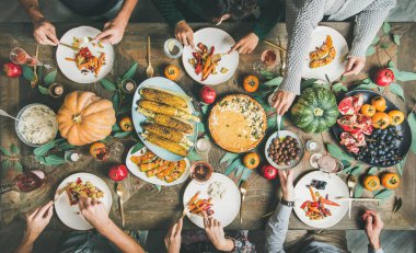 Vegan veya vejetaryen Şükran günü, Friendsgiving tatil kutlaması. Düz-lay kabak pasta, kavrulmuş sebze, meyve ve gül şarap, en iyi görünümü ile Şükran günü masada yemek arkadaş