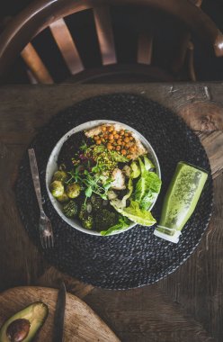 Sağlıklı akşam yemeği veya öğle yemeği ayarı. Vegan superbowl veya buda kase humus, sebze, taze salata, fasulye, kuskus ve avokado ve masada yeşil yüzlü, üst görünümü ile Düz yatıyordu