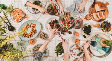 Aile ya da arkadaşlar akşam yemeği topluyor. Halkların elleri, kavrulmuş kuzu omuz, salatalar, sebzeler, gül şarabı, beyaz damalı masa örtüsü üzerinde mimoza dalları, üst görünümü düz yatıyordu. Kutlama partisi akşam yemeği