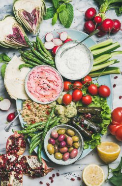 Sağlıklı vegan atıştırmalık seti. Pancar humusu, yoğurt, ot daldırma, zeytin, gözleme, kus kus, dolma, sebze ve meyve mermer arka plan üzerinde tepsi üzerinde düz yatıyordu, üst görünümü. Temiz yeme gıda kavramı