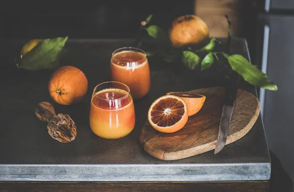在混凝土厨房柜台上 两杯鲜榨的血橙汁或冰沙和新鲜水果 健康的生活方式 碱性饮食 春季排毒概念 — 图库照片