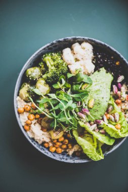 Sağlıklı akşam yemeği veya evde öğle yemeği. Vegan superbowl veya Buda kase humus, sebze, taze salata, fasulye, kuskus ve koyu arka plan üzerinde avokado, üst görünümü ile