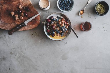 Sağlıklı vegan kahvaltı. Düz-meyve, tohum, fındık, çilek ve masa arka plan üzerinde kahve ile Quinoa yulaf granola hindistan cevizi yoğurt kase yatıyordu, üst görünüm, kopya alanı. Vejetaryen, temiz yemek yeme konsepti
