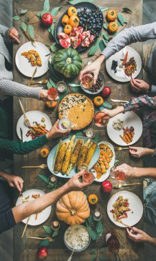 Vegan, vejetaryen Şükran Günü, Friendsgiving kutlaması. Kabak pasta, sebze, meyve, şarap, üst görünüm, dikey kompozisyon ile Şükran Günü masada gözlük klinking arkadaşlar Flat-lay