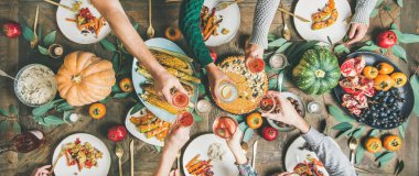 Vegan, vejetaryen Şükran Günü, Friendsgiving tatil kutlaması. Kabak pasta, sebze, meyve, şarap, üst görünüm, geniş kompozisyon ile Şükran Günü masada gözlük klinking arkadaşlar Flat-lay