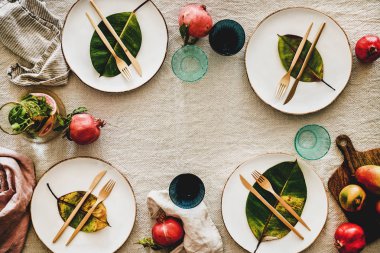 Bayram yemeği için sonbahar ya da sonbahar sofrası. Çarşaf masa örtüsü, üst manzara, fotokopi alanı üzerine meyve ve düşmüş yapraklarla bezenmiş yemek takımı. Şükran Günü ya da Noel için hazırlık