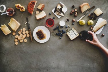 Şarap çeşitleri. Peynir, bal, meyve, fındık, kraker ve bardaktaki şarap kaba gri arka plan, üst manzara, kopyalama alanı. Toplanma, tatil, parti yemeği konsepti