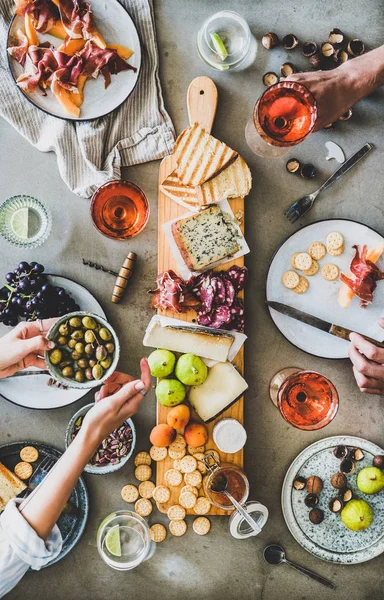 간식을 곁들인 보드의 견과류 올리브와 사람들 음식을 콘크리트 테이블 — 스톡 사진