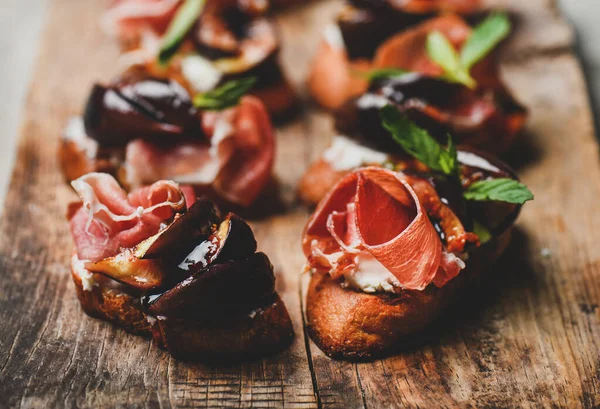 聚会或饮食食品的概念 木板上有意大利木薯 羊乳酪和烤无花果的克罗提尼 有选择性的焦点 水平组合 — 图库照片