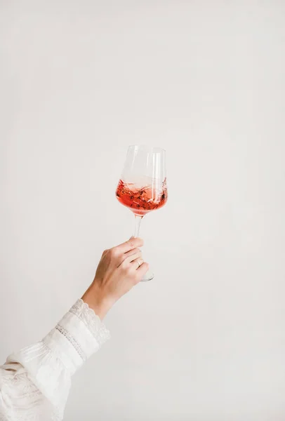 Mano Mujer Camisa Blanca Sosteniendo Girando Copa Vino Rosa Sobre — Foto de Stock