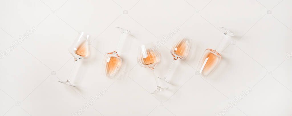 Rose wine variety layout. Flat-lay of rose wine in various wineglasses over plain white background, top view. Summer drink for party or picnic, wine shop or wine tasting concept