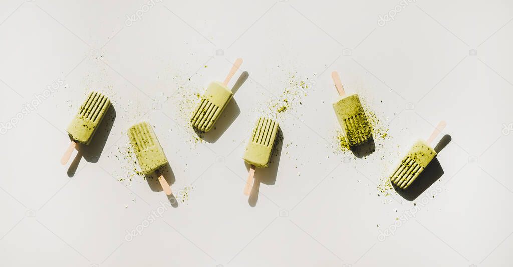 Green matcha coconut vegan ice cream popsicles with green tea powder. Flat-lay of matcha popsicles over light background, top view. Summer healthy dessert, clean eating, dairy free food concept