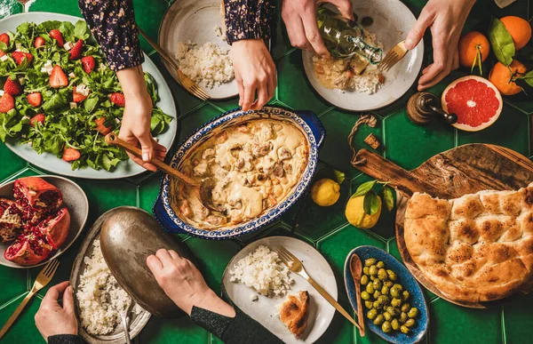 一家人在吃土耳其菜 人们的平铺手与羊肉一起享用酸奶酱 新鲜的牛油果和草莓沙拉 米皮拉夫和扁平面包 尽收眼底 Ramazan Iftar晚餐 — 图库照片