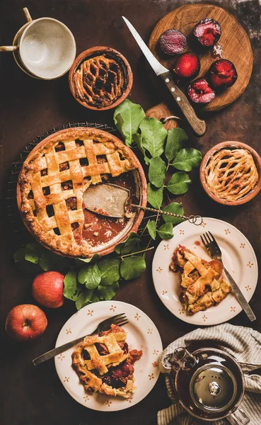 秋のお茶の時間設定 暗い錆びたテーブルの背景の上にポットでお茶とラックの上にリンゴと梅のパイのフラットレイアウト トップビュー 甘い快適食品のコンセプトを秋 — ストック写真