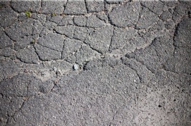 Kırık asfalt ve yol yüzeyindeki çatlaklar.