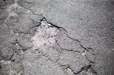 Kırık asfalt ve yol yüzeyindeki çatlaklar.