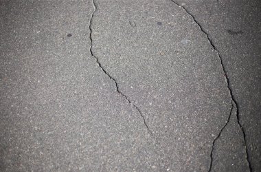 Kırık asfalt ve yol yüzeyindeki çatlaklar.