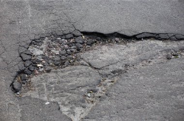 Kırık asfalt ve yol yüzeyindeki çatlaklar.