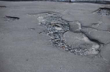 Kırık asfalt ve yol yüzeyindeki çatlaklar.