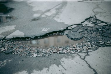 Kırık asfalt ve yol yüzeyindeki çatlaklar.