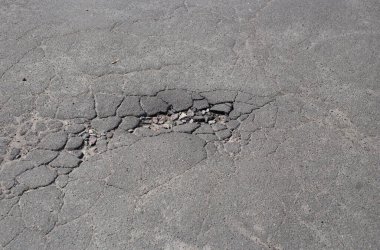 Kırık asfalt ve yol yüzeyindeki çatlaklar.