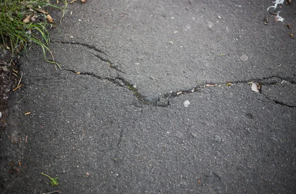 道路表面の壊れたアスファルトや亀裂 — ストック写真