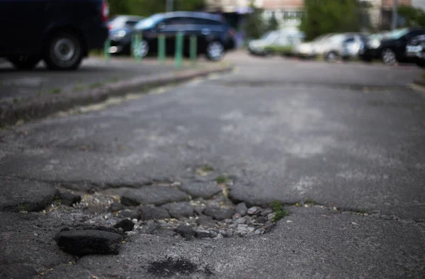 Broken asphalt and cracks on the road surface