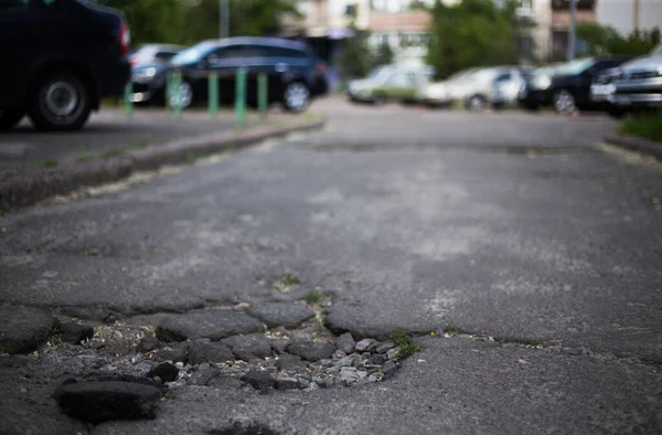 Broken asphalt and cracks on the road surface