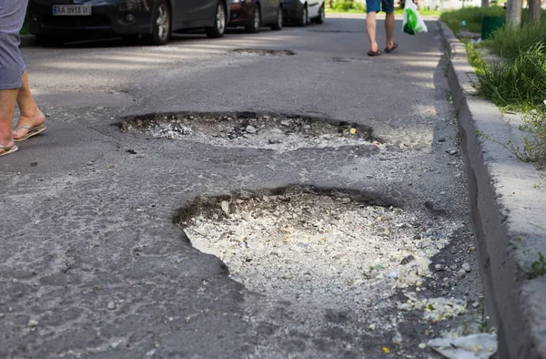 Broken asphalt and cracks on the road surface