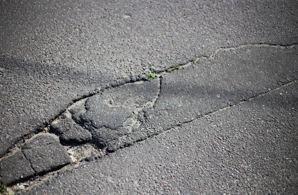 Kırık asfalt ve yol yüzeyindeki çatlaklar.