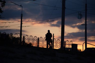 Günbatımında arka planda bir adamın silueti