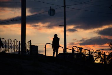 Günbatımında arka planda bir adamın silueti