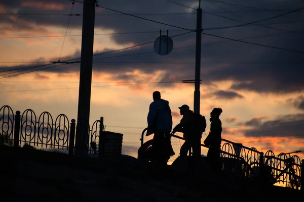 Silhouette of a man on a sunset background in the sity