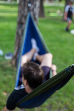 Genç adam yazın hamakta dinleniyor.