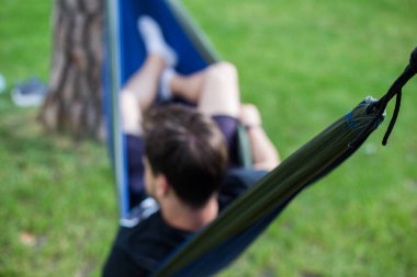 Genç adam yazın hamakta dinleniyor.