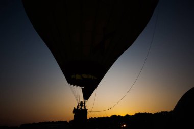 Sıcak hava balonu gökyüzünde gün batımında