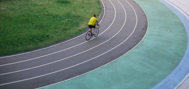 Bir adam stadyumda bisiklet sürüyor.